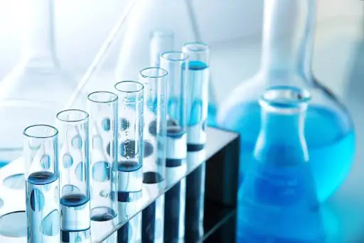 Different laboratory glassware with color liquid and with reflection